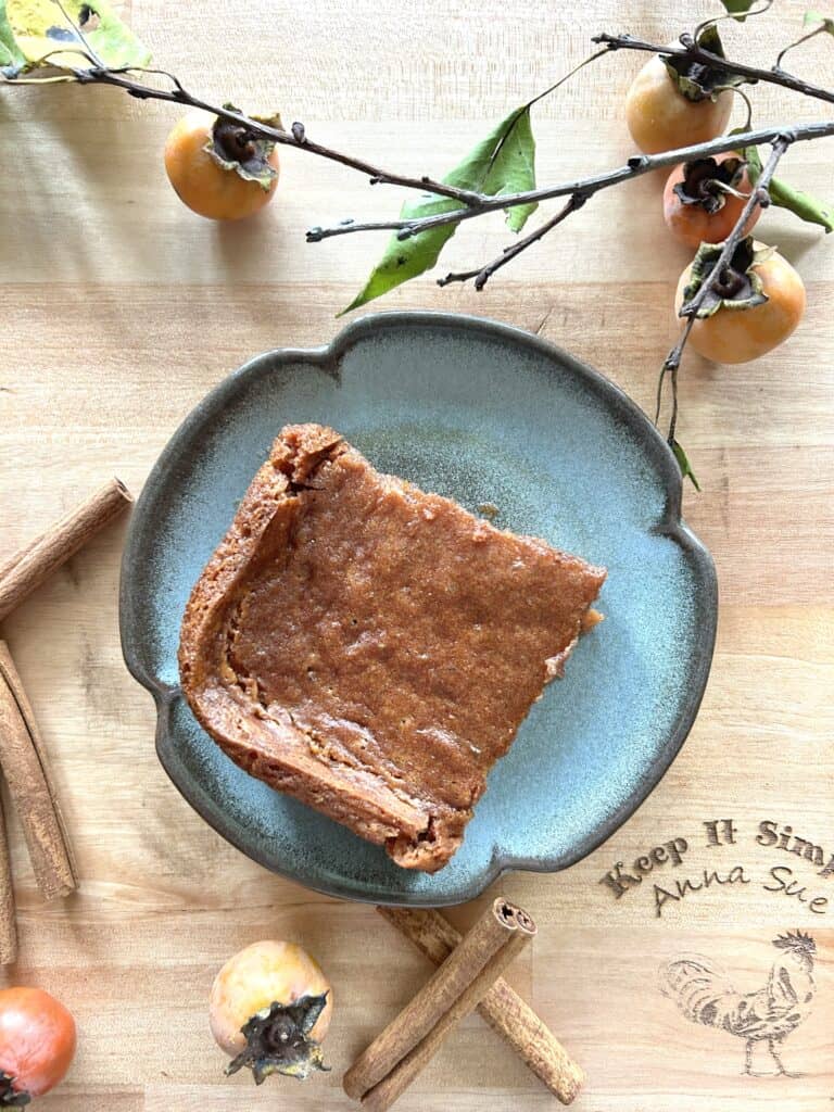 made-from-scratch-traditional-family-recipe-persimmon-pudding-with-cinnamon-sticks-fresh-persimmons-overhead-shot