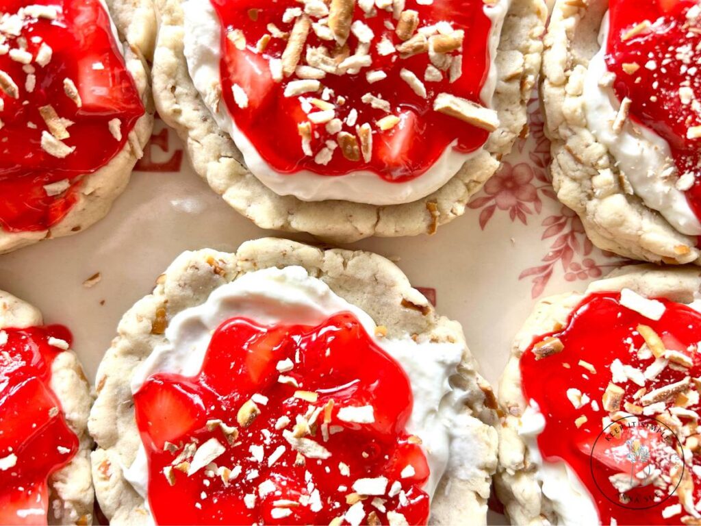six-strawberry-pretzel-pie-cookies-with-a-cream-cheese-filling-and-topped-with-a-strawberry-glaze-on-a-beautiful-red-plate-topped-with-pretzel-pieces-1.jpg