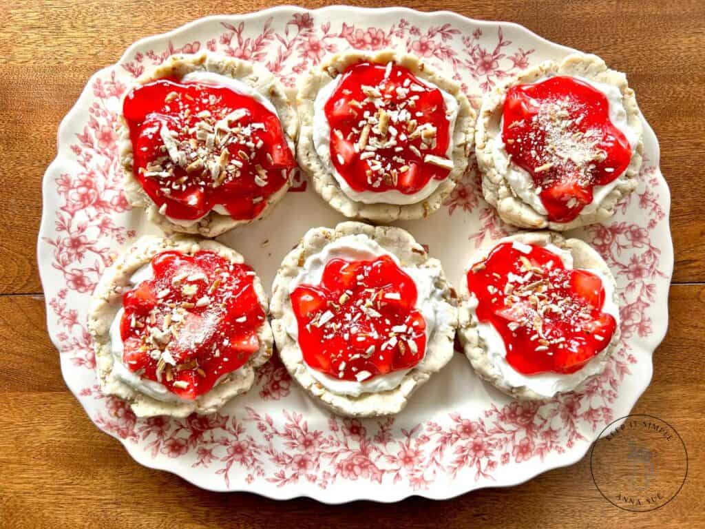 six-strawberry-pretzel-pie-cookies-with-a-cream-cheese-filling-and-topped-with-a-strawberry-glaze-on-a-beautiful-red-plate-topped-with-pretzel-pieces.jpg