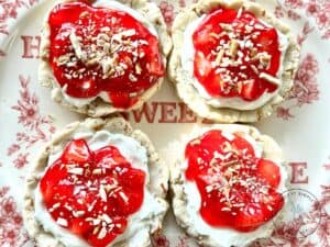 strawberry-pretzel-pie-cookies-with-a-cream-cheese-filling-and-topped-with-a-strawberry-glaze-on-a-beautiful-red-plate-topped-with-pretzel-pieces.jpg