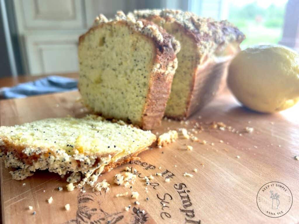 baked-lemon-poppy-seed-streusel-bread-on-a-wire-cooling-rack-with-a-blue-towel-and-fresh-lemons-2.jpg