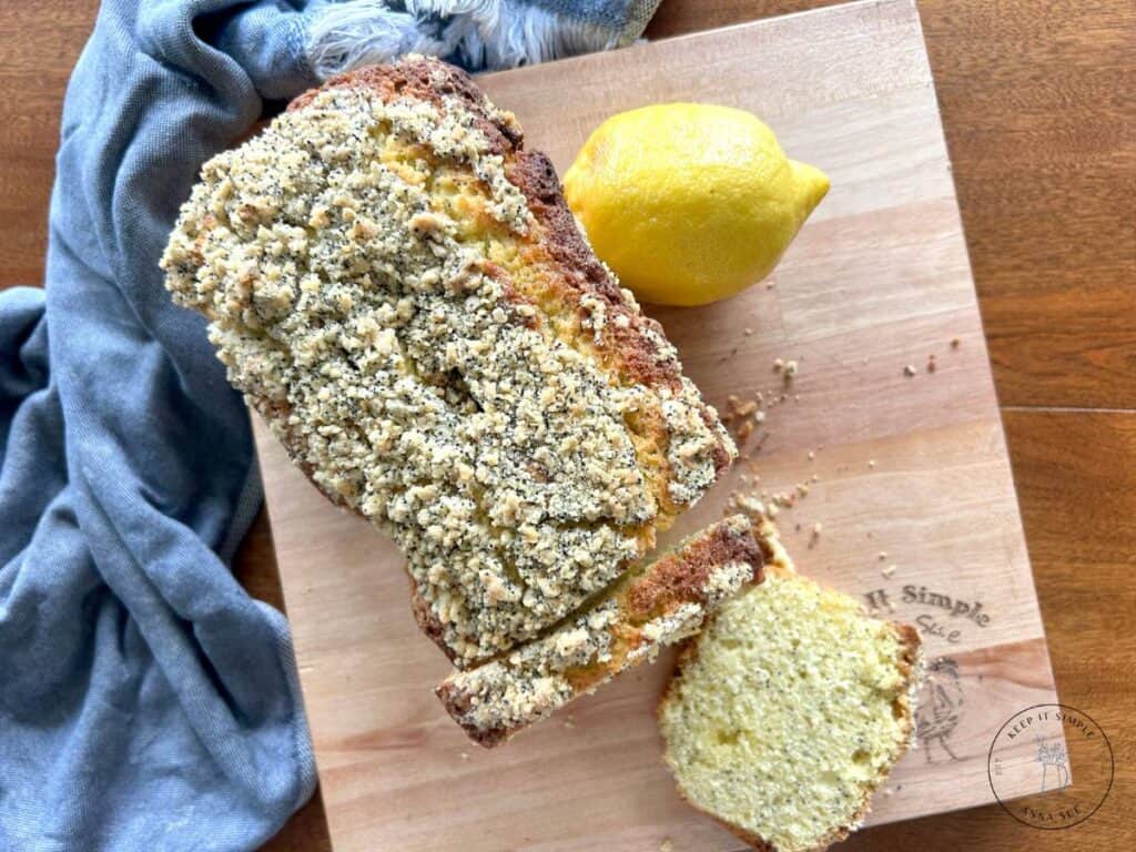 baked-lemon-poppy-seed-streusel-bread-on-a-wire-cooling-rack-with-a-blue-towel-and-fresh-lemons-3.jpg