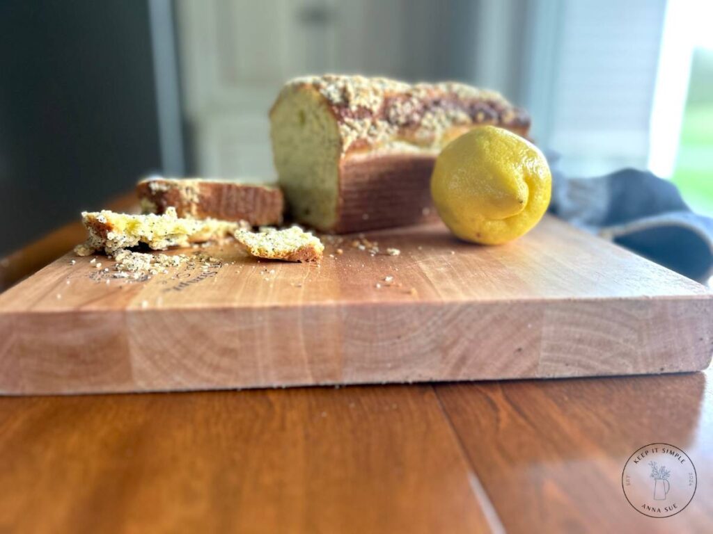 baked-lemon-poppy-seed-streusel-bread-on-a-wire-cooling-rack-with-a-blue-towel-and-fresh-lemons-5.jpg