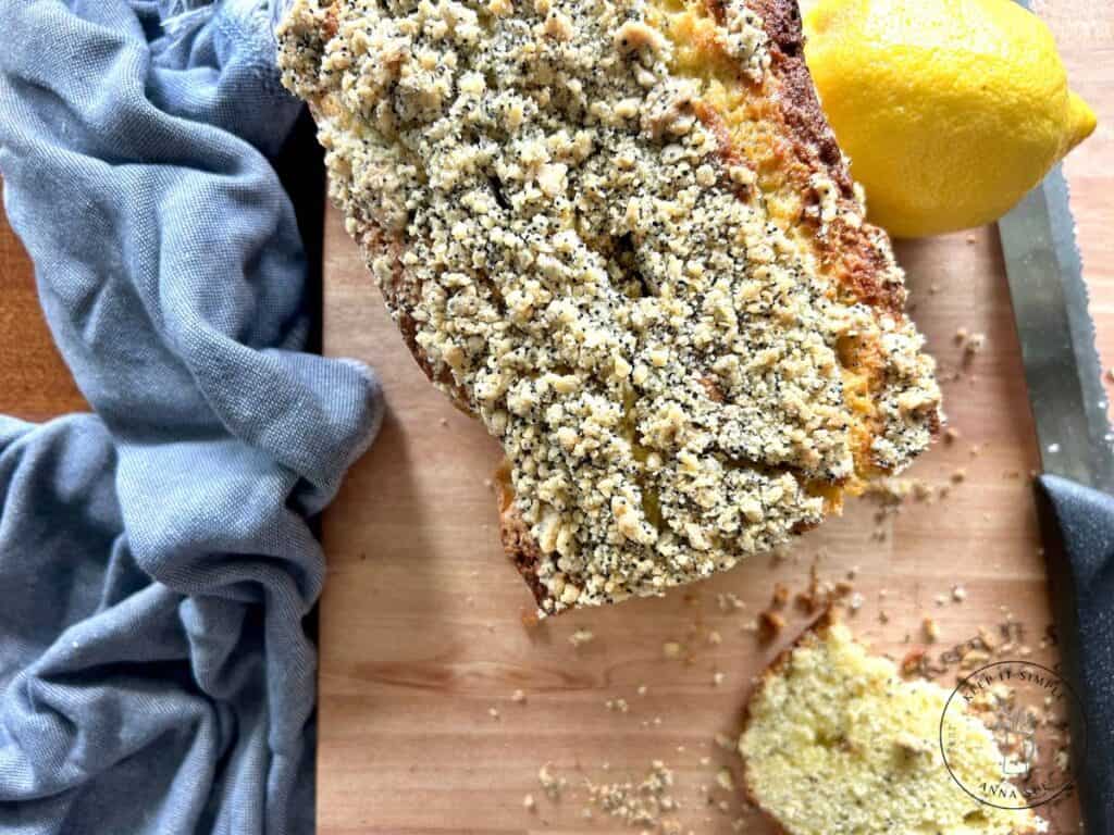 baked-lemon-poppy-seed-streusel-bread-on-a-wire-cooling-rack-with-a-blue-towel-and-fresh-lemons-7.jpg
