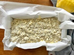lemon-poppy-seed-streusel-bread-topped-with-streusel-in-a-pan-lined-with-parchment-paper.jpg